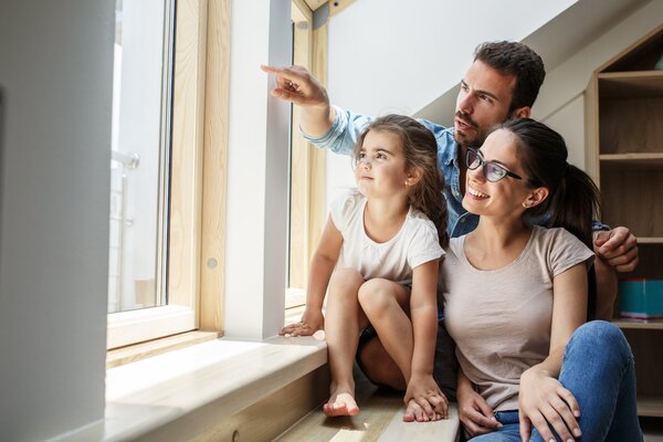 Portrait of young family.They sitting by the window in living ro